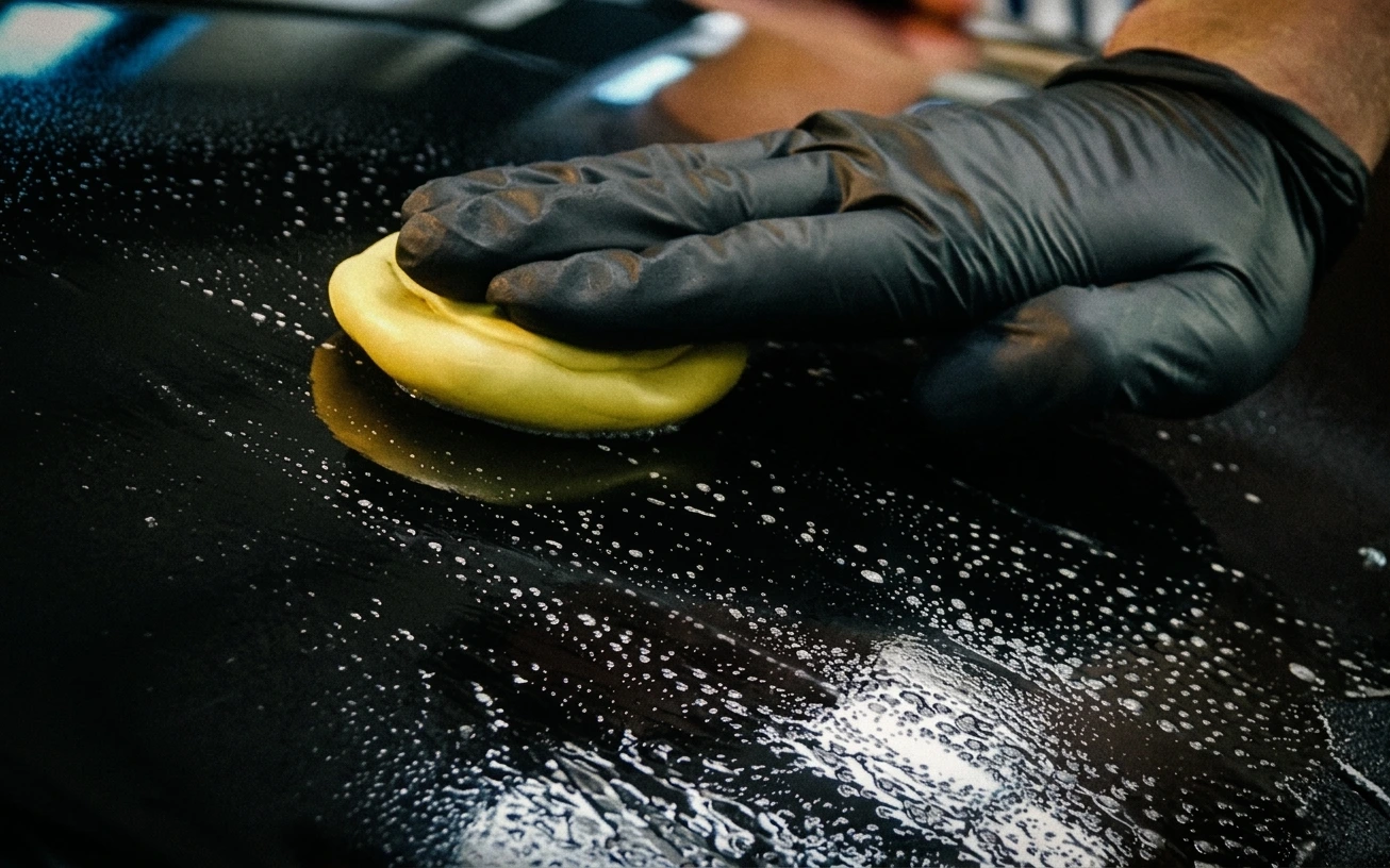 Clay bar treatment removing bonded contamination from car paint with lubrication